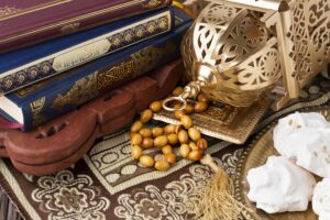 Stack of Islamic books with an ornate gold lamp and prayer beads (Tasbih)